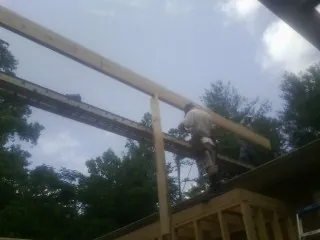 Carpenter setting a ridge beam over a new addition frame — Ice Dam Removal by Roofing Brothers in Prospect Heights