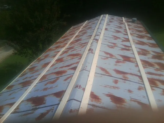 Rusted metal roof panels with new wood purlins before replacement — Storm Damage Roof Repair in Prospect Heights by Roofing Brothers