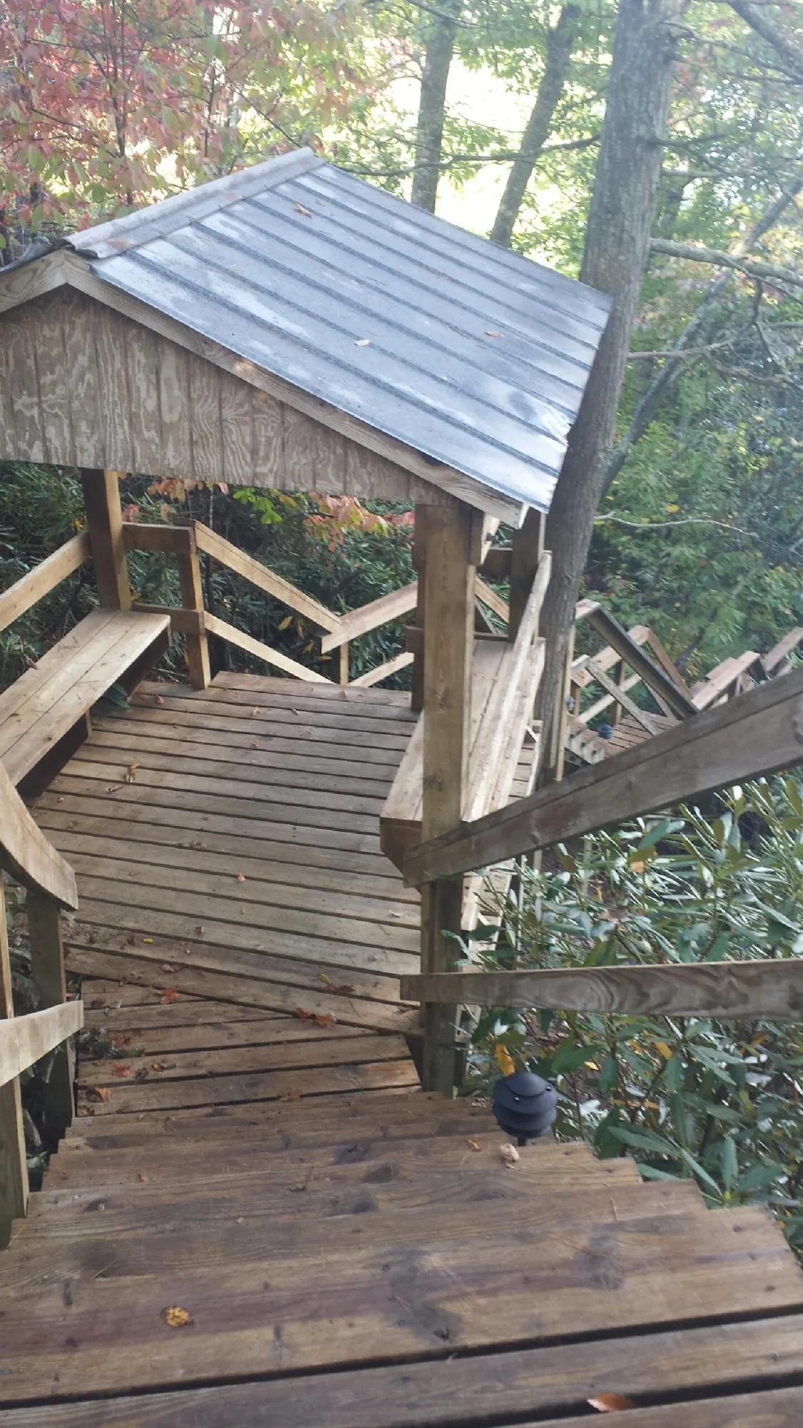 Metal roofed shelter over wooden steps on a wooded walkway — Skylight Repair & Installation work by our crew in Prospect Heights