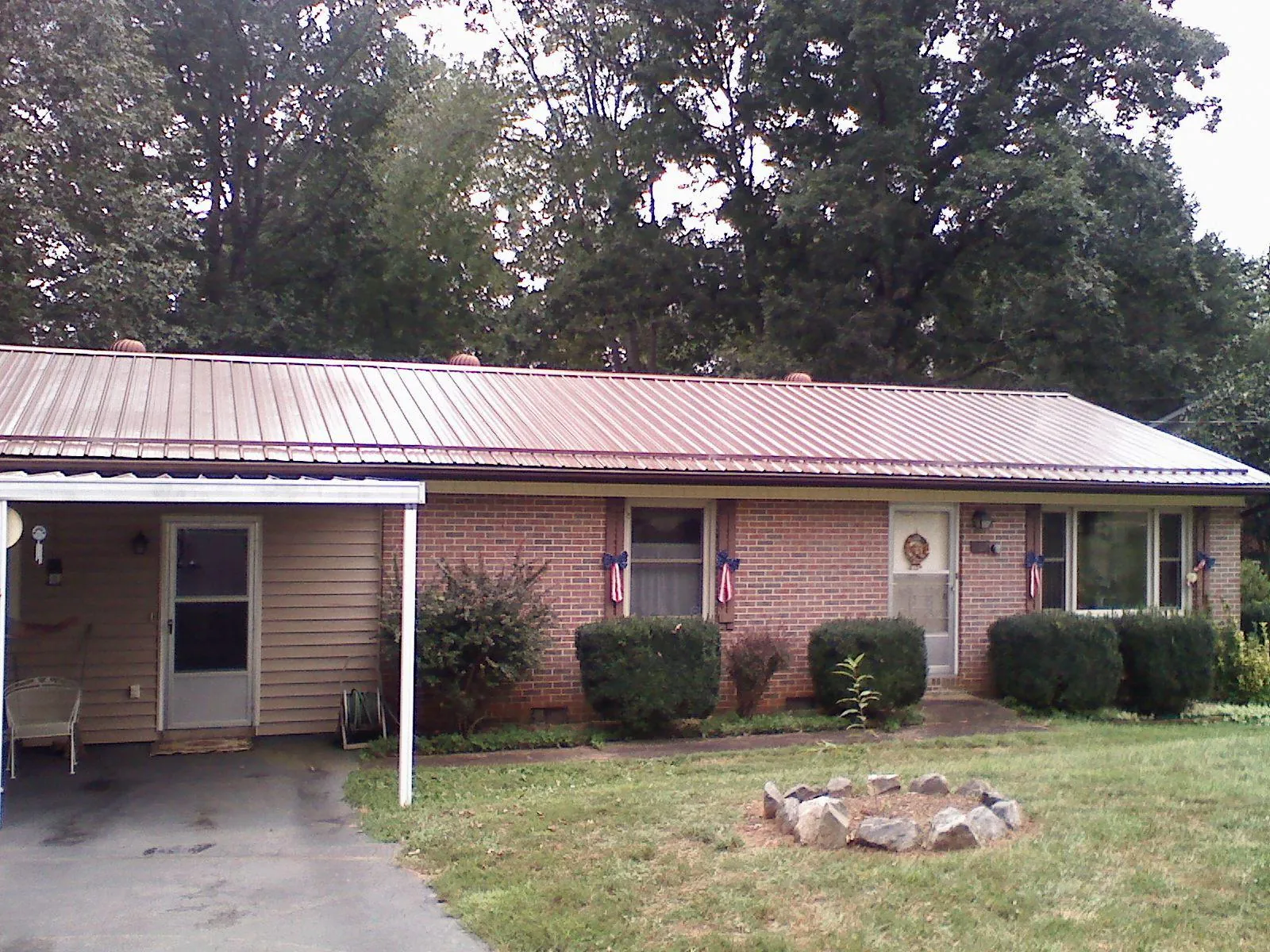 Bronze metal roof and carport on a brick ranch home — Roof Repair work by our crew in Prospect Heights